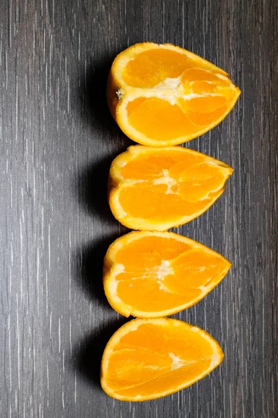 オレンジ色の果物 黒い木の つのオレンジ スライスと部分分離します — ストック写真