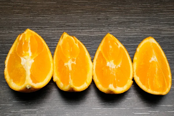 Orange fruit. four orange slice and pieces isolate on black wood.