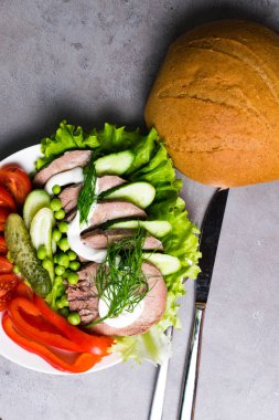 haşlanmış sebze domates biber salatalık marul bezelye mayonezli diliyle, gri tabloda ekmek