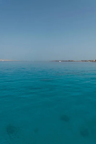 背景の海岸と紅海の地平線の間セーリング ヨットの距離で — ストック写真
