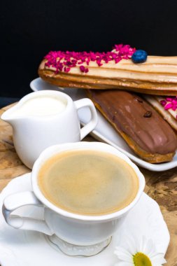 taze kahve, krema ve kahve çekirdekleri, papatya sürahi ile ahşap siyah plaka.