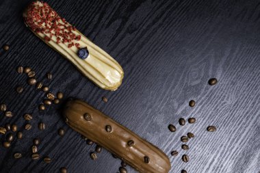 Geleneksel Fransız çikolata, yaban mersini, woodn arka plan üzerinde ahududu ile kahve eklerleri