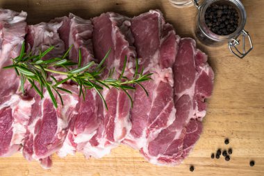 Kara biber ve biberiye ahşap arka plan üzerinde kesme tahtası üzerinde taze Çiğ domuz