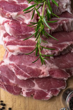 Biberiye rustik tarzı ahşap arka plan üzerinde çiğ domuz biftek parçaları