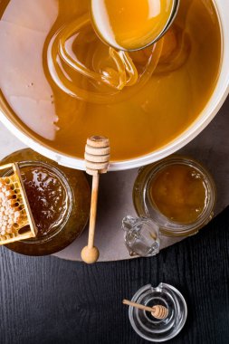 Kavanoz ve büyük kova, petek ve tahta sopa, metal kepçe tatlım