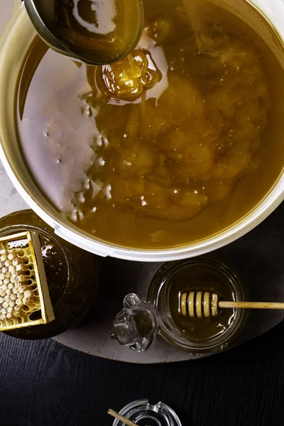 Čerstvý med v bílém bloku a sklenice, voštinové, dřevěné hole — Stock fotografie