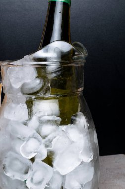 Şampanya veya soğuk buz sürahi göl kenarında siyah arka plan üzerine beyaz şarap şişe