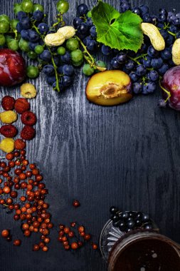 yiyecek zengin resveratrol, üzüm, Erik, goji, fıstık, kızılcık, raspberrys koyu çikolata, siyah ahşap zemin üzerine kırmızı şarap