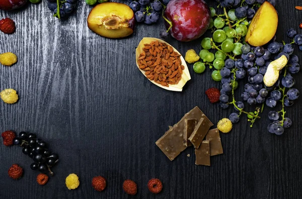 food for your health. Brain boosting health food background border with nuts, fruit, chocolate, goji, raspberrys, grapes. Food high for vitamins, minerals, antioxidants and anthocyanins. Space for text