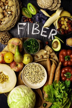 Çavdar Galette'ye, buğday kepeği, fasulye, badem, tohum, armut, Erik muz, böğürtlen, ahududu, Antep fıstığı, kırmızı biber kivi ceviz kavun kereviz havuç ahşap masa arka plan olarak olarak lif açısından zengin gıdalar