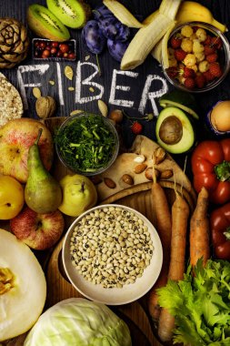 Çavdar Galette'ye, buğday kepeği, fasulye, badem, tohum, armut, Erik muz, böğürtlen, ahududu, Antep fıstığı, kırmızı biber kivi ceviz kavun kereviz havuç ahşap masa arka plan olarak olarak lif açısından zengin gıdalar