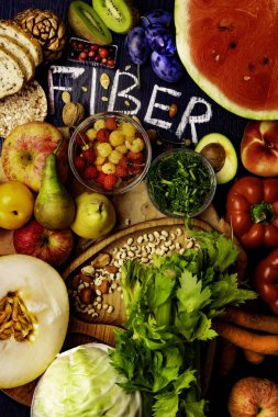 Çavdar Galette'ye, ekmek, watermeon, buğday kepeği, fasulye, badem, tohum, armut, Erik muz, böğürtlen, ahududu, Antep fıstığı, kırmızı biber kivi ceviz kavun kereviz havuç ahşap masa arka plan olarak olarak lif açısından zengin gıdalar