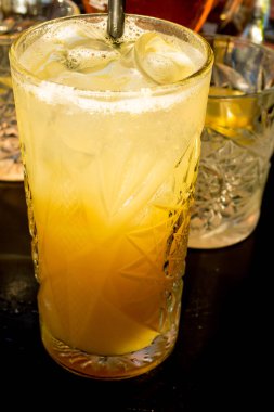 Taze turuncu alkol kokteyl içki ve iki bardak martini şarap, siyah arka plan üzerine limon dilimleri