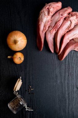 Çiğ domuz eti veya sığır eti dilleri karabiber cam, siyah ahşap, gourment gıda anlayışı üzerinde soğan ile