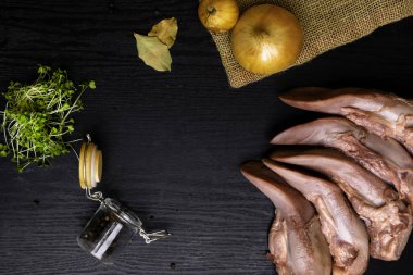 karabiber cam ile Çiğ domuz eti veya sığır eti dilin, bay yapraklar, çul, siyah ahşap masa, gourment gıda anlayışı üzerinde tere salatası soğan