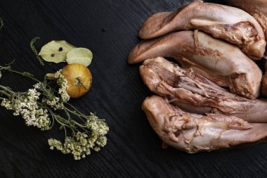 beş küçük Çiğ domuz eti veya sığır eti dilleri kekik, karabiber, defne yaprağı, soğan, gourment gıda anlayışı, metin için boş alan ile siyah ahşap tablo