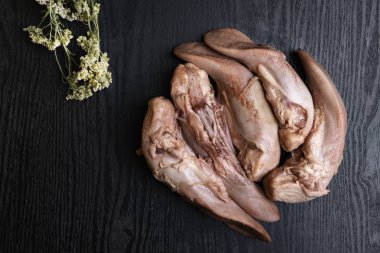 Çiğ domuz eti veya sığır eti dilleri ile kekik, gourment gıda anlayışı, siyah ahşap masa üzerinde boş alan metin