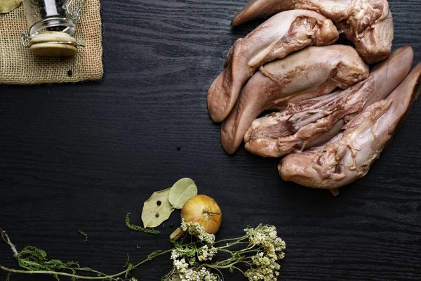 karabiber cam kavanoz, kekik, çul soğan, defne yaprağı siyah ahşap masa, gourment gıda anlayışı, metin için boş alan ile Çiğ domuz eti veya sığır eti dilleri