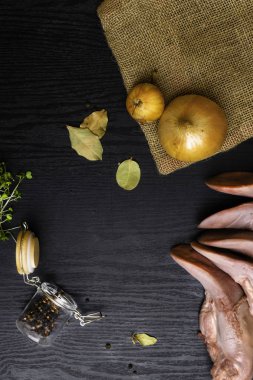 karabiber cam ile Çiğ domuz eti veya sığır eti dilin, bay yapraklar, çul, siyah ahşap masa, gourment gıda anlayışı üzerinde tere salatası soğan