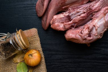 karabiber cam ile Çiğ domuz eti veya sığır eti dilin, bay yapraklar, çul, siyah ahşap masa, gourment gıda anlayışı üzerinde tere salatası soğan