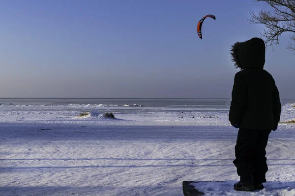 Bambino Guardando Fuori Aquilone Che Vola Nel Cielo Blu Inverno — Foto stock gratuita