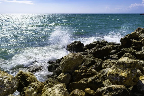 明るい黄色の石を青い海サーフィン波の背景 青い海 ヨットを離れて リラクゼーションの晴れた日にスプレー — ストック写真