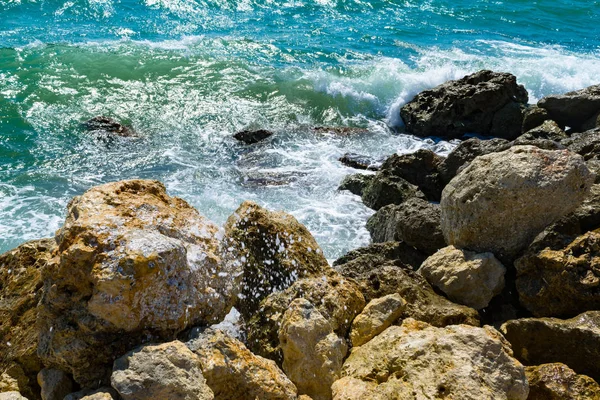 明るい黄色の石を青い海サーフィン波 青い海と海岸 リラクゼーションに晴れた日にスプレー — ストック写真
