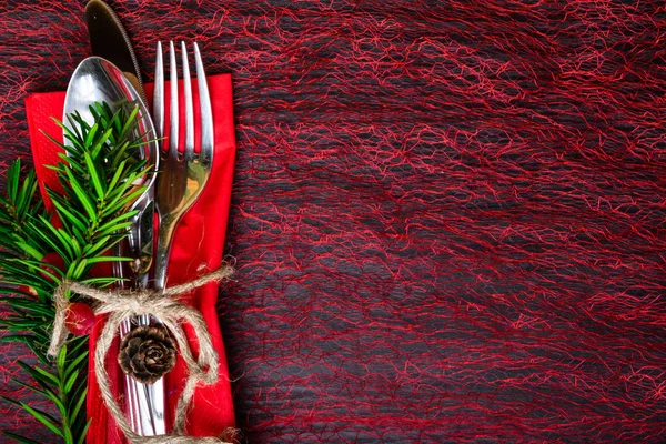 Christmas and New Year holiday table setting, fork, spoon, knife with thread , Christmas tree branch and berry, spruce cones. Celebration place setting for dinner decorations. Copy space. Top view.