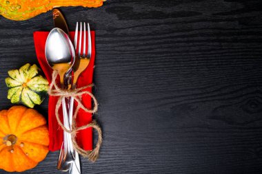 Sonbahar arka plandan pumpkins, kaşık, çatal, bıçak iplik yay, siyah ahşap masa vintage yer ayarı ile ayarla. Şükran günü kavramı