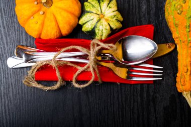 Sonbahar arka plandan pumpkins, kaşık, çatal, bıçak iplik yay, siyah ahşap masa vintage yer ayarı ile ayarla. Şükran günü kavramı