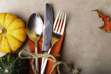 Düşmüş kırmızı yaprakları ve kabak kırmızı peçeteye taş masada gümüş yer ayarı ile sonbahar kökenli. Şükran günü kavramı