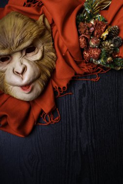 Kırmızı ekose ve maymun maskesi siyah arka plan, tatil, üstten görünüm, mutlu yeni yıl Noel güzel çelenk