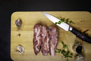 Yeşillik, sarımsak, biber ve ahşap tahta üzerinde bıçak ile - koyun - kuzu eti. Üstten görünüm.