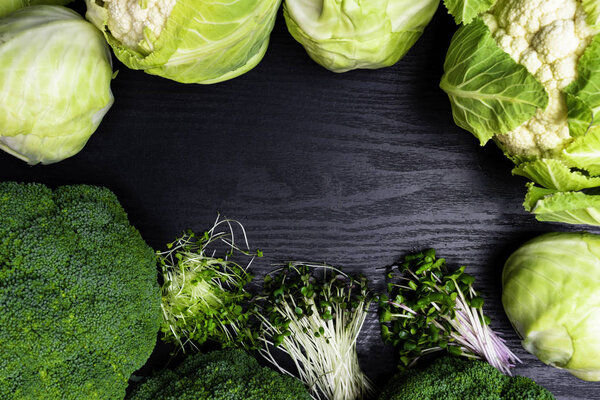 Цветная капуста, белая капуста, брокколи, зеленая редиска, салат кресс, аругула, горчица. Здоровый образ жизни, пребывание молодой и современной кухни ресторан концепции изолированы на деревянном фоне
