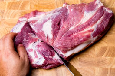 Şef kasap kesim domuz eti yemek yemek mutfak ahşap tahta üzerinde bıçak ile