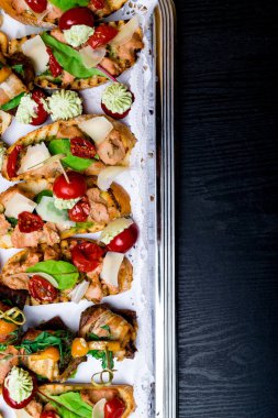 küçük kanepeler üzerinde metal Kaset döşeme arka plan. Meze somon pate, jambon, mozzatella, yeşil ile dekore edilmiş pesto ile yapraklar, salata kopya alanı