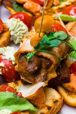 Tatlım agaric, mozzarella, pesto, pastırma, salata ile ev yapımı bruschetta yapraklar, domates, beyaz masaya krem