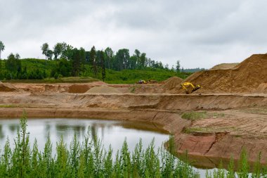 sarı ekskavatör ve traktör sandpit hafriyat çalışmaları sırasında suyla
