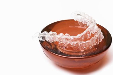 İzole şeffaf diş protez aligner kırmızı stand ile beyaz üzerinde çok güzel bir gülümsemen bir şekilde izole.