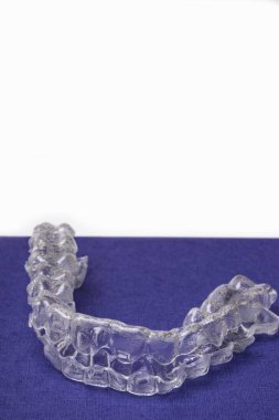 Inivisalign diş teli veya aligner. Güzel bir gülümseme ve beyaz dişler kopya alanı ile mavi stand için bir yol