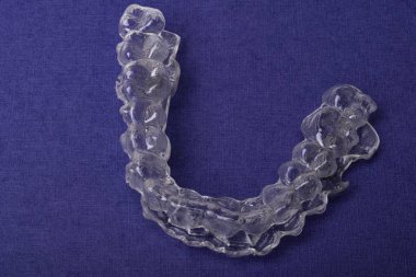 Inivisalign diş teli veya aligner. Güzel bir gülümseme ve beyaz dişler kopya alanı ile mavi stand için bir yol