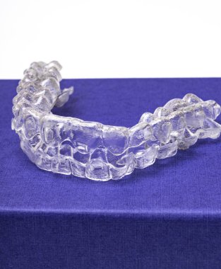 Inivisalign diş teli veya aligner. Güzel bir gülümseme ve beyaz dişler kopya alanı ile mavi stand için bir yol