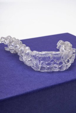 Inivisalign diş teli veya aligner. Güzel bir gülümseme ve beyaz dişler kopya alanı ile mavi stand için bir yol