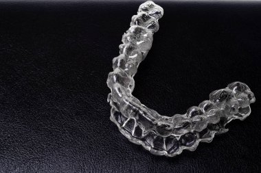 Inivisalign diş teli veya aligner. Güzel bir gülümseme ve beyaz dişler kopya alanı ile siyah arka plan üzerine bir şekilde