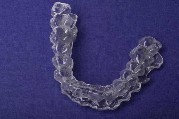 Inivisalign braces or aligner. A way to have a beautiful smile and white teeth on blue stand with copy space