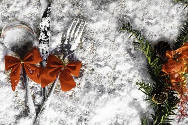 Noel masa çatal, kaşık ve bıçak dekorasyon koniler, yay, şube ile karlı arka plan, yeni yıl ve Noel tatil kavramı üzerinde ayarla