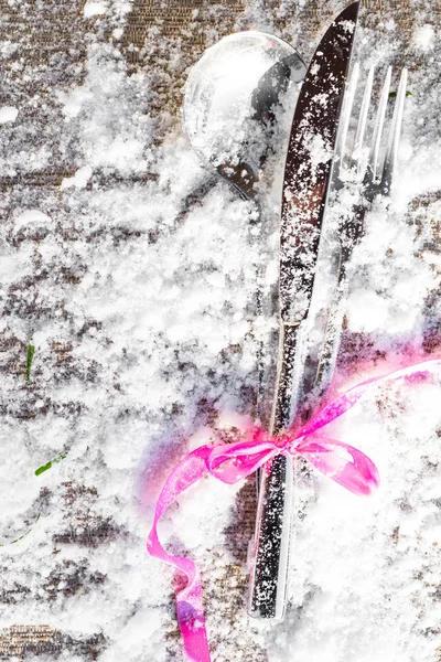 Cutlery with pink ribbon as border on white background with copy space. Christmas, new year, 14th february festive dinner and restaurant theme texture and background