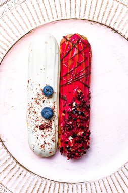 Kırmızı ahududu ve yaban mersini eklerleri beyaz plaka üzerinde beyazla