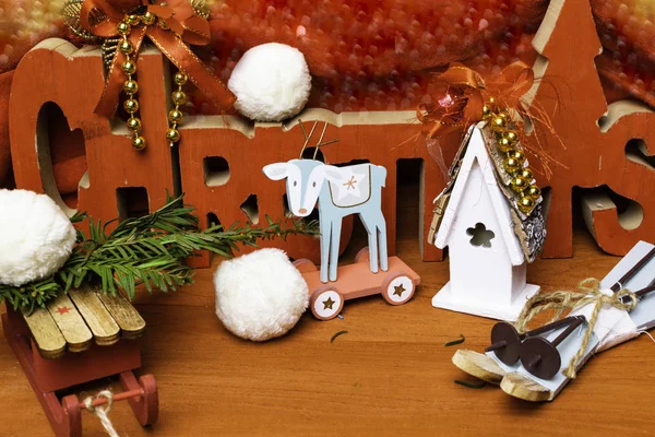 festive christmas background with toy deer, house, sledge, ski and snow