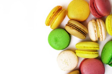Tatlı badem renkli pembe, sarı, yeşil, kahverengi macaron ya da beyaz arka plan üzerinde izole acıbadem kurabiyesi tatlı pasta. Fransız tatlı kurabiye. Çok az yiyecek ekmek kavramı. üstten görünüm, kopya alanı